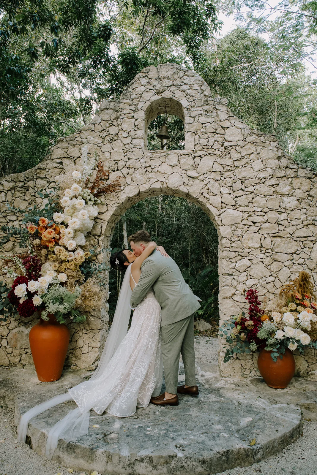 Aleah y Matthew besándose frente a la capilla de piedra en Villa Onze Xpu-Ha
