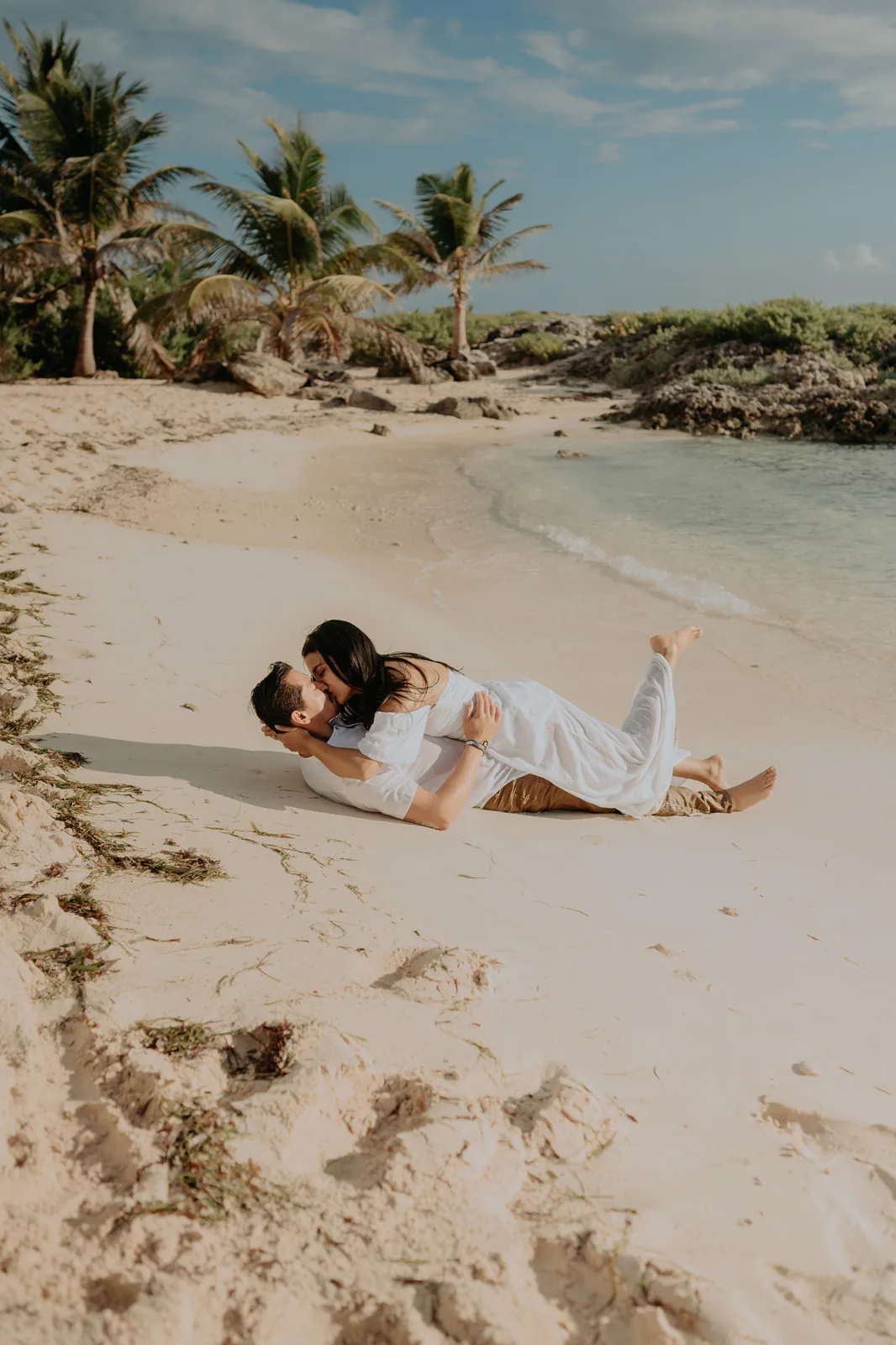 Pareja besándose en la playa durante una sesión al amanecer en Isla Mujeres